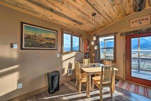 a dining room with a table and chairs and windows at Couples Retreat 1-Hour Drive from Yellowstone NP! in Livingston