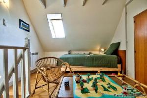 a bedroom with a bed and a table with toys on it at Gîte Le pied à terre in Kerlouan