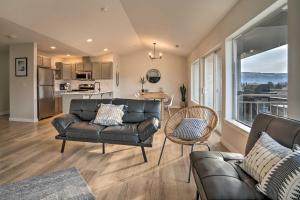 a living room with a leather couch and a kitchen at Chic Chelan Condo with Balcony, Walk to Lake and Dtwn! in Chelan