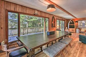 einen großen Holztisch in einem Zimmer mit einem großen Fenster in der Unterkunft Waterfront Pet-Friendly Whitefish Lake Home with Dock in Pine River
