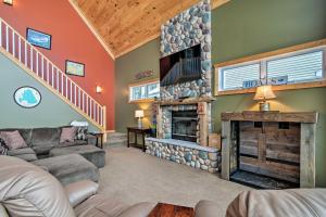 una sala de estar con chimenea de piedra en una casa en Family-Friendly Lake Mitchell Oasis Hike and Ski! en Cadillac