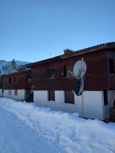 una casa en la nieve con un satélite en Jahorina apartman Košuta D5, en Jahorina