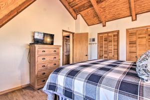 een slaapkamer met een bed en een tv op een dressoir bij Luxe Gatlinburg Cabin with Panoramic Views and Hot Tub! in Gatlinburg