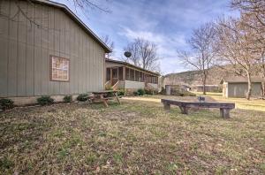 a picnic table and a bench in front of a building at White River Getaway with Fire Pit and Trout Fishing! in Mountain View