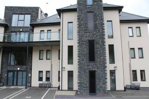 a large white building with windows and a balcony at Llys Marina in Y Felinheli
