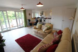 a living room with a couch and a kitchen at Llys Marina in Y Felinheli