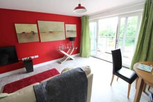 a red living room with a couch and a table at Llys Marina in Y Felinheli