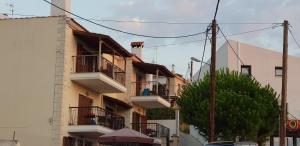 an apartment building with balconies and a tree at Filidas Apartments in Skiathos