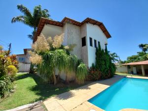 una casa con piscina frente a ella en Kaizuka - Casa c/ Piscina, en Guarapari