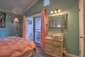 ein Schlafzimmer mit einem Bett, einem Waschbecken und einem Spiegel in der Unterkunft Lakeside Pleasure Island Cabin with Deck and Gas Grill in Farmerville