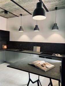 een keuken met een tafel en drie hanglampen bij 5 Star Apartments - Luxury & Comfort in Jelenia Góra