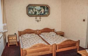 a bedroom with a wooden bed and a painting on the wall at Pension Familia in Harrachov