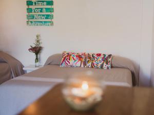 a couch with a pillow and a candle on a table at La Playita Beach House in Puerto Escondido