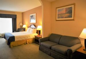 a hotel room with a bed and a couch at Oasis Inn & Suites 29 Palms Hotel Joshua Tree National Park in Twentynine Palms +59 photos