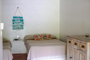 a bedroom with a bed and a wooden cabinet at La Playita Beach House in Puerto Escondido