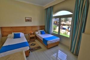 A bed or beds in a room at Sheikh Ali Dahab Resort