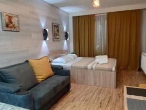 ein Hotelzimmer mit einem Sofa und einem Bett in der Unterkunft New Gudauri loft1 in Gudauri