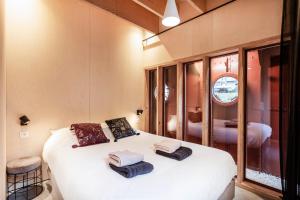 Un dormitorio con una cama blanca con toallas. en Juno Boat, en Gante