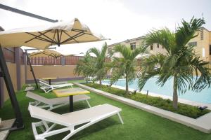a patio with chairs and an umbrella and a pool at Cocktail and Dreams Hotel in Accra