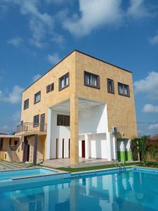 a building with a swimming pool in front of it at Cocktail and Dreams Hotel in Accra