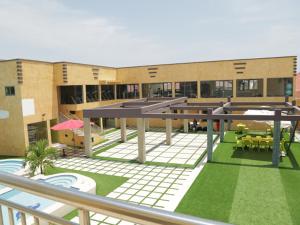 a building with a courtyard with a pool and tables at Cocktail and Dreams Hotel in Accra