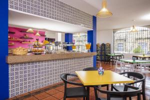 restauracja z żółtym stołem i krzesłami w obiekcie Vista Express Morelia by Arriva Hospitality Group w mieście Morelia