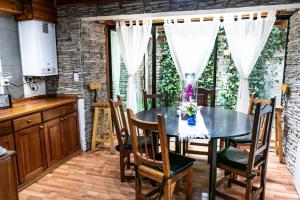 cocina y comedor con mesa y sillas en Cabañas de la Patagonia en San Martín de los Andes