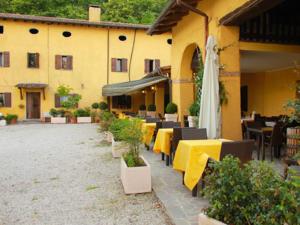 a restaurant with tables and chairs and a yellow building at Agriturismo Ca Noale in Teolo