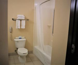 a bathroom with a toilet and a shower with towels at Oasis Inn and Suites Joshua Tree -29 Palms in Twentynine Palms