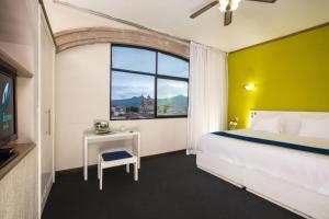 Säng eller sängar i ett rum på Vista Express Morelia by Arriva Hospitality Group
