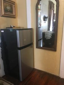a refrigerator in a room with a mirror at Charming Historic Downtown Apartment in Saint Augustine