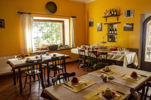 un ristorante con tavoli e sedie in una stanza con pareti gialle di Cerqueti agriturismo a Baschi