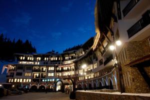 a large building at night with lights on at GRAND MONASTERY Apartments in Pamporovo