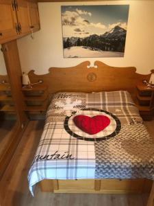 a bedroom with a bed with a red heart on it at CASA VACANZE MIRAMONTI - appartamento con balcone con vista sulle Dolomiti in Borca di Cadore
