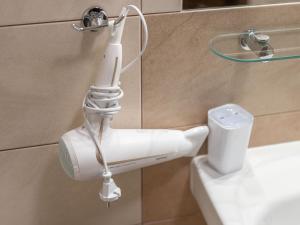 コウォブジェクにあるAquaBaltic Apartments Aquariusの浴室のホルダーにぶら下がっている白い電動歯ブラシ +23枚の写真