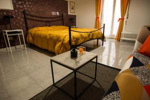 ein Schlafzimmer mit einem Bett und einem Tisch darin in der Unterkunft Casa Agorà in Palazzolo Acreide