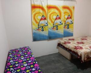 een slaapkamer met een bed en een schilderij van drie zeilboten bij Chacara Recanto do Carlão in Biritiba-Mirim