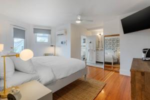 a white bedroom with a bed and a bathroom at The Shore House in Narragansett