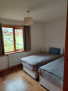 Duas camas num quarto com uma janela em 19 Drumcoura Lake Resort em Ballinamore