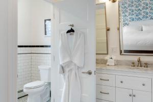 a white bathroom with a toilet and a sink at The Shore House in Narragansett