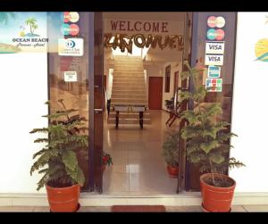 an entrance to a welcome morgue with potted plants at Hotel Ocean Beach Paracas in Paracas