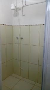 um chuveiro com uma mangueira na casa de banho em Quarto Aconchegante em São Bento do Sapucaí