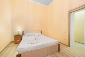 um quarto com uma cama com lençóis brancos e uma janela em Apartment near Deribasovskaya em Odessa