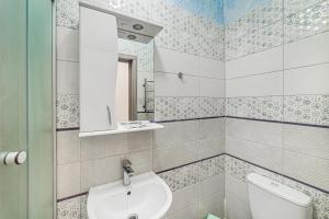 uma casa de banho com um lavatório, um WC e um espelho. em Apartment near Deribasovskaya em Odessa