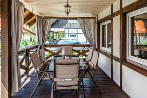 - une terrasse couverte avec une table et des chaises dans l'établissement Dom Kaszubski nr 65, à Załakowo