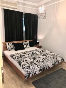 a bedroom with a bed with a black and white comforter at Knez Mihailova, Beograd in Belgrade