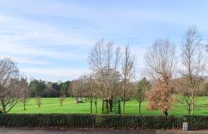 ein grünes Feld mit Bäumen und einem Zaun in der Unterkunft Park View - 4 Star Luxury in Belfast