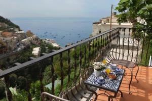 a table on a balcony with a view of the ocean at Gema Suites in Positano