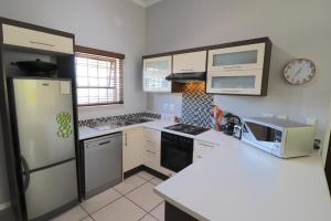 a kitchen with a refrigerator and a stove top oven at Carole's Cottage in Hermanus