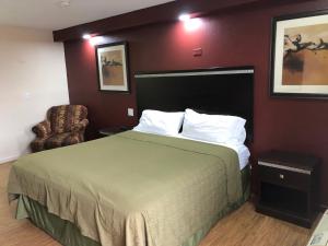 a hotel room with a bed and a chair at Crossroads Inn in Lebanon